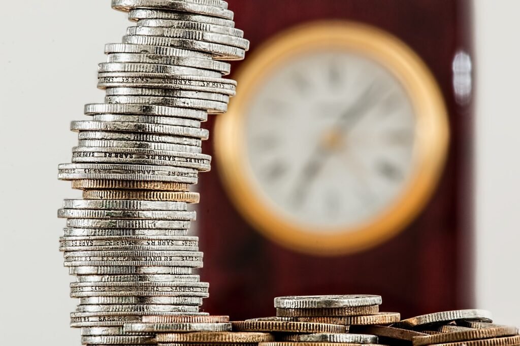 Una torre de monedas con un reloj de fondo