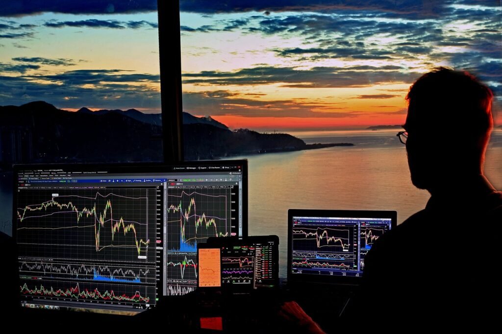Un hombre mirando varias pantallas de trading de bolsa y un atardecer en el mar de fondo